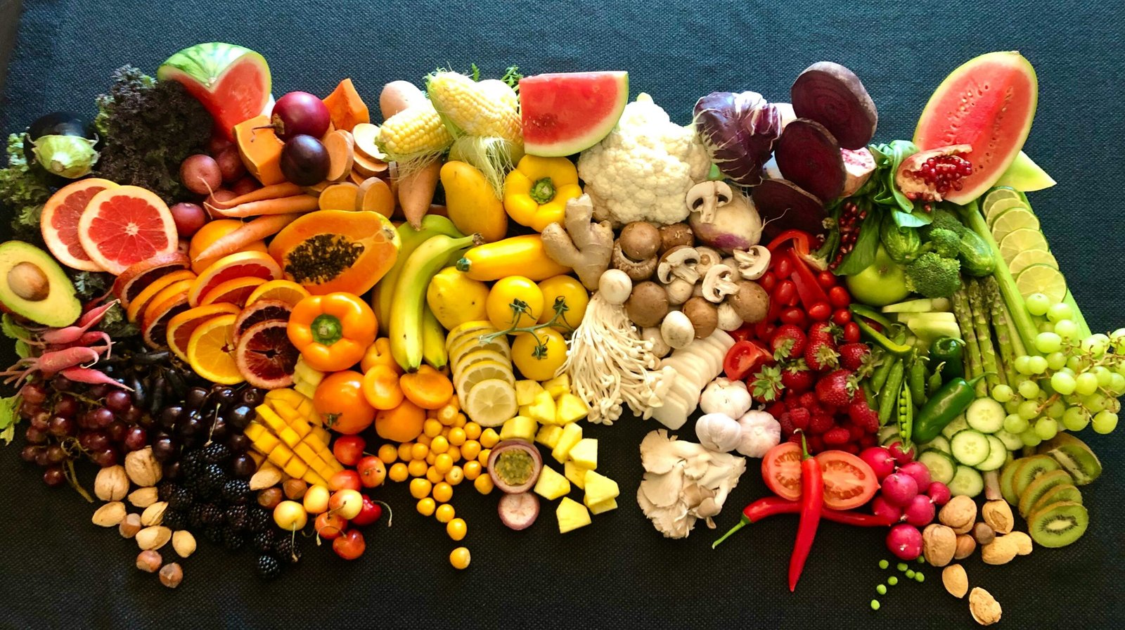 Table packed with fruits and vegetables that have different fibre contents.